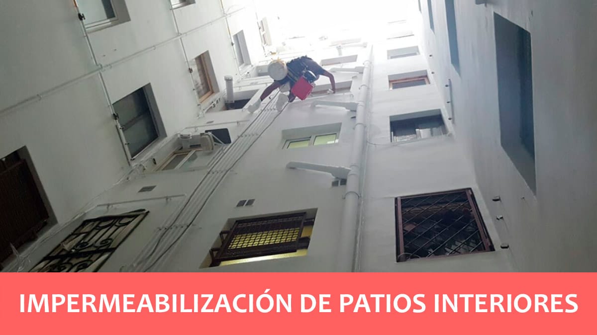 Operario realizando trabajos verticales en un patio interior de una comunidad en Barcelona
